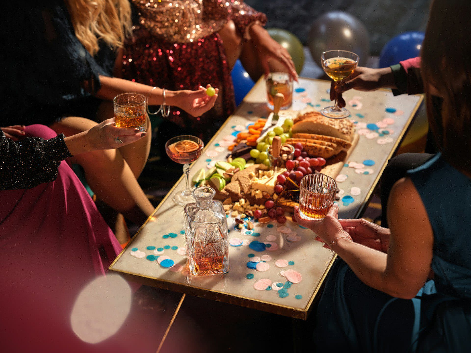 Party table with whisky decanter and a cheeseboard